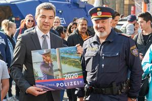 Innenminister Wolfgang Peschorn hält einen neuen Wiener Polizeikalender in Händen.